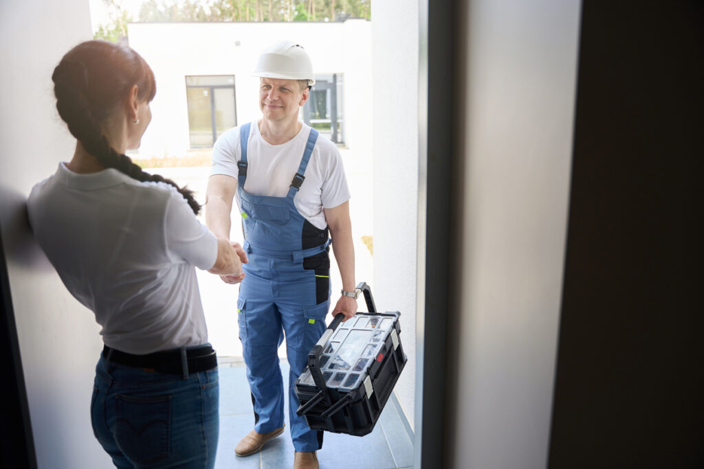 A friendly Plumber greeting a homeowner at their door