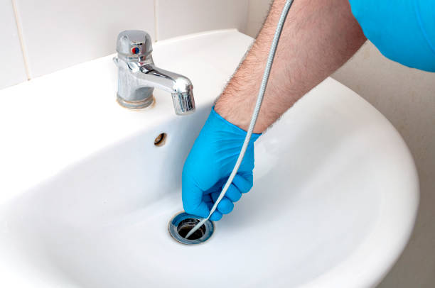 Plumber using a drain snake for professional drain repair services