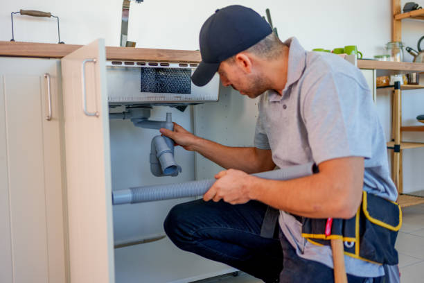 Plumber checking under-sink plumbing for slab leak detection