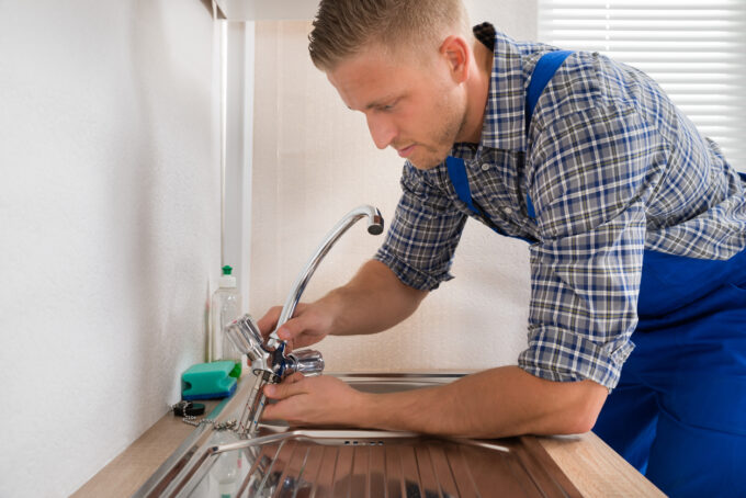 Plumber fixing a faucet to resolve a leak during fixture repair service