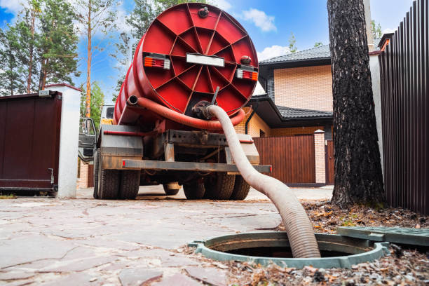 Large sewer cleaning truck pumping out sewage from residential sewer
