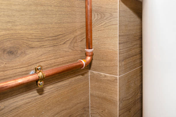 Freshly installed copper pipes along tiled wall after repiping service